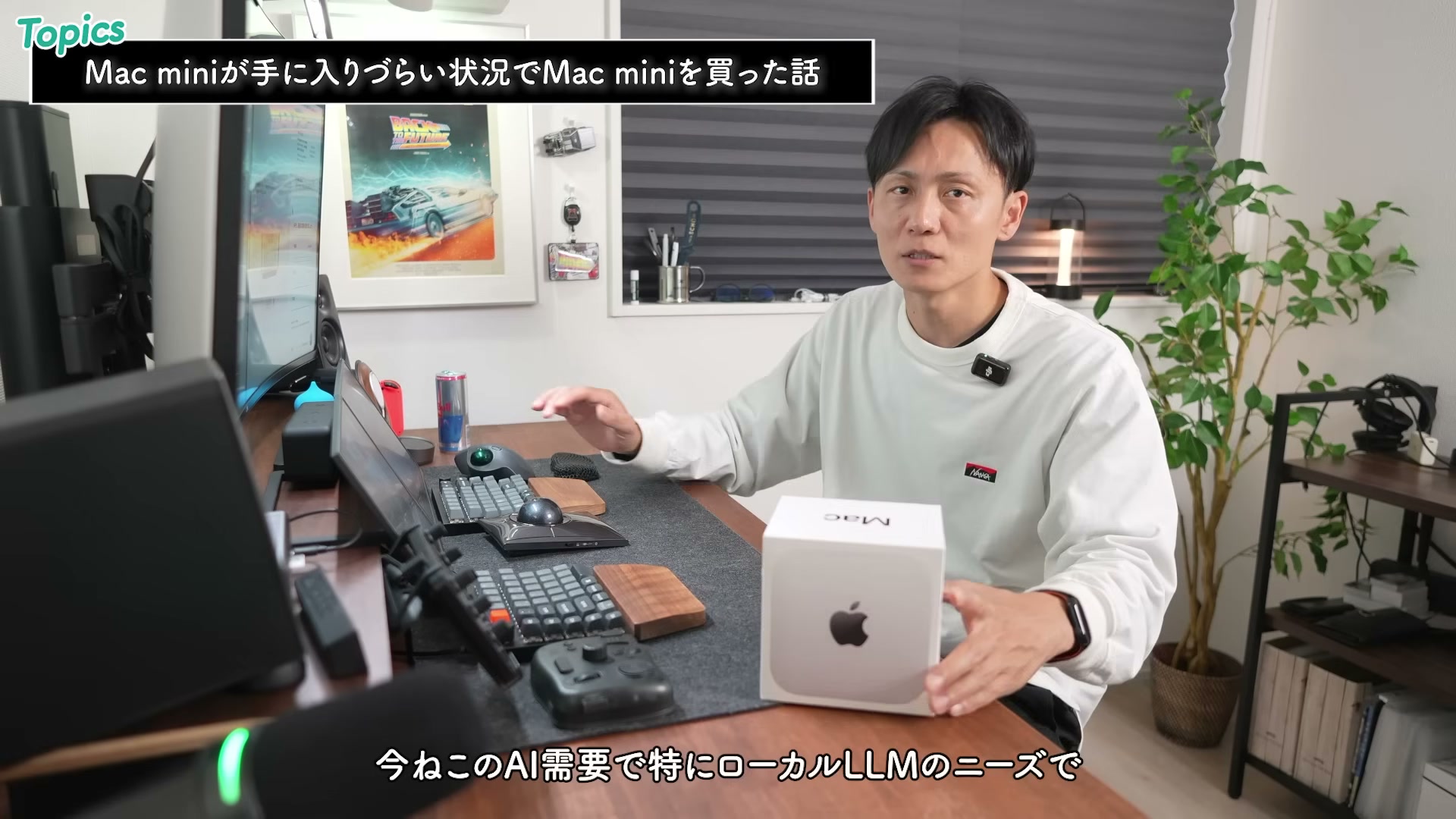 Mac miniの箱を持って解説する様子