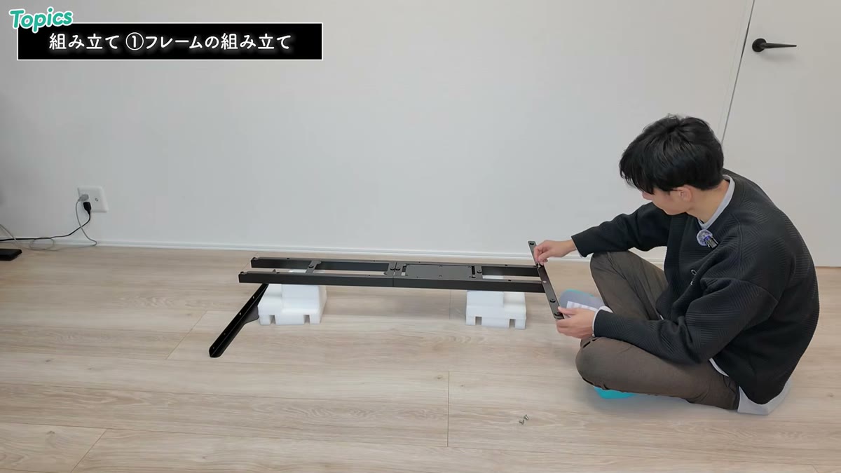 床でFlexiSpot E7のフレームを組み立てる