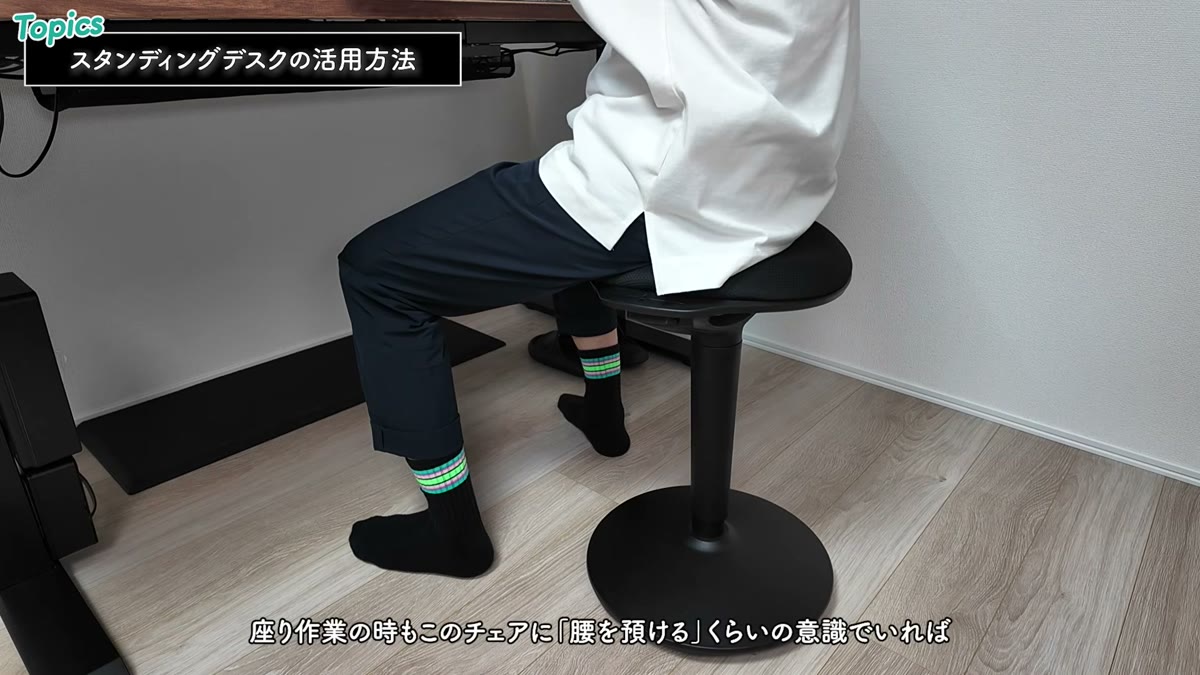 スタンディングデスク対応の昇降チェアに腰を預ける